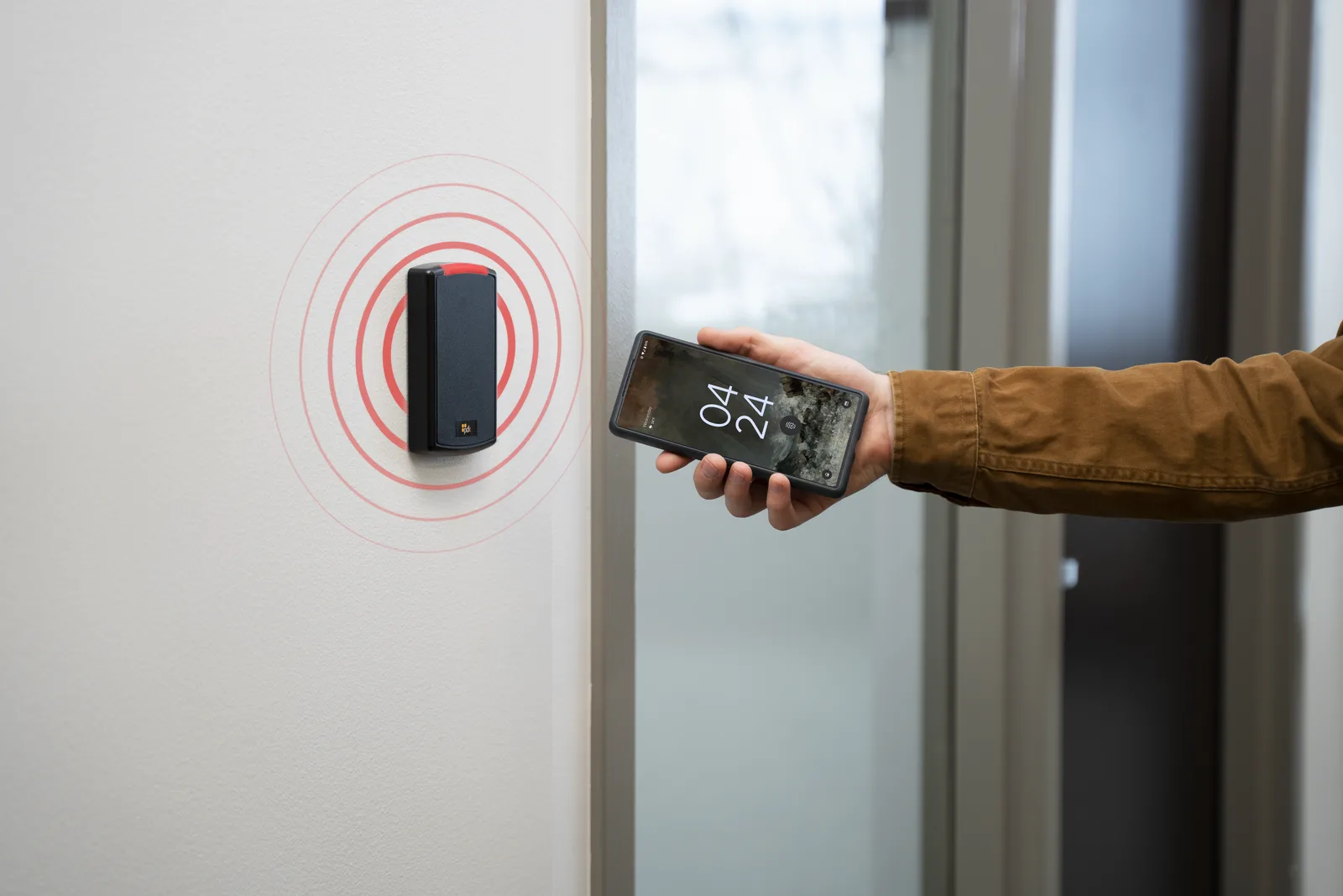 Smartphone unlocking a cloud-based access control reader beside an office door
